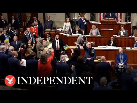 Representatives celebrate and wave flags after US Congress passes Ukraine aid package