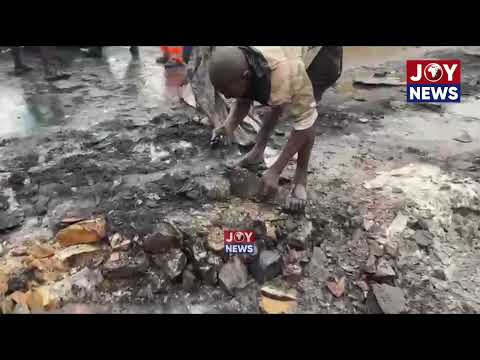 Scrap dealers collecting scrap while the Fire Service works to evacuate the remains.