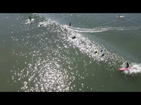 Surfistas capturados desde un dron na praia estatal de Doheny