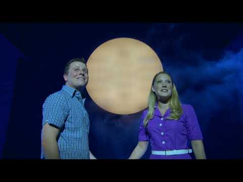 Promo button: Darryl’s silhouette under spotlight as the company hits a final chord