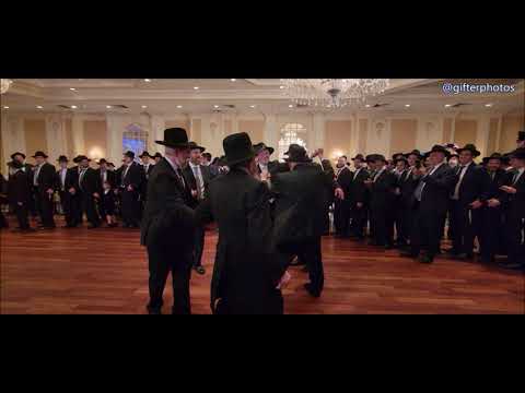Rav Shmuel Kaminetsky  whispers to Chosson that he should dance with Rav Schachter