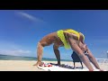 THICKFIT MODEL DEMONSTRATES LYING YOGA POSES ON THE BEACH WomenToWatch SQUATS StressRelieve