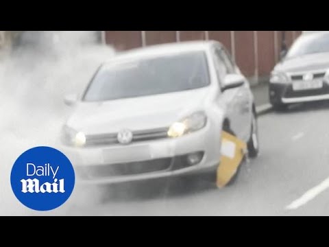 Crazy moment man tries to drive car with clamped wheel - it does not end well!