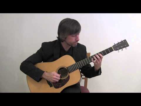 guy in suit playing acoustic guitar: width=