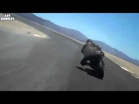 un fou  a moto fait frotter son casque par terre