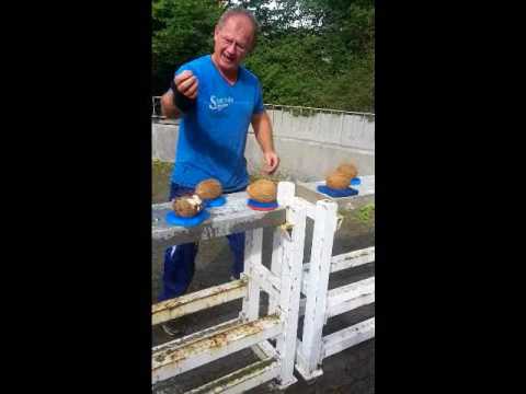 Most Coconuts smashed by hand while holding an egg in 60 seconds