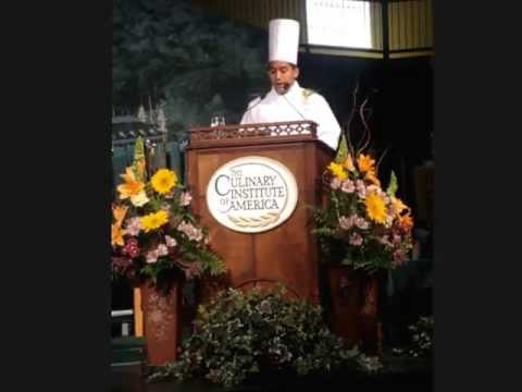 CIA alumni Thomas Zacarias at a podium making the valedictorian speech at CIA commencement.