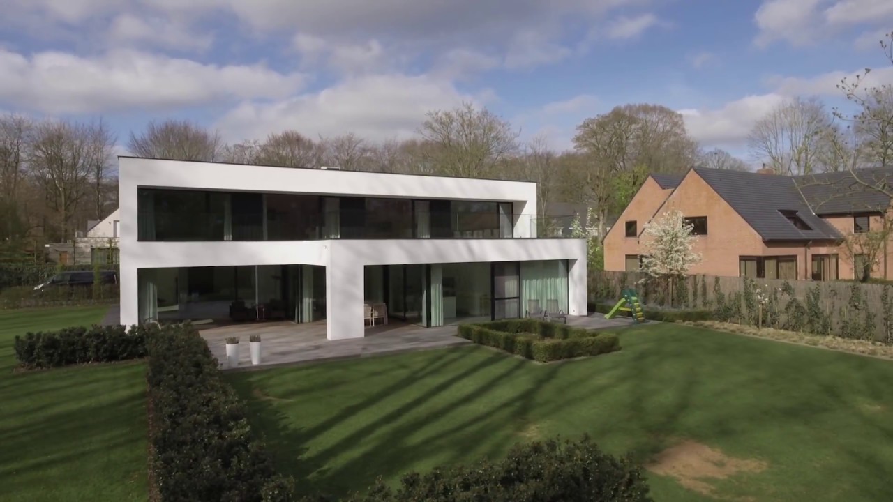 Strakke witte woning in groene omgeving
