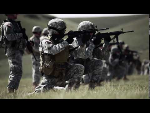 Soldiers kneel to fire rifles
