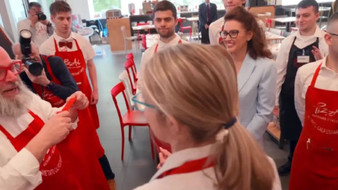 Meloni indossa il grembiule di PizzAut, durante la visita al ristorante di Monza per il Primo Maggio