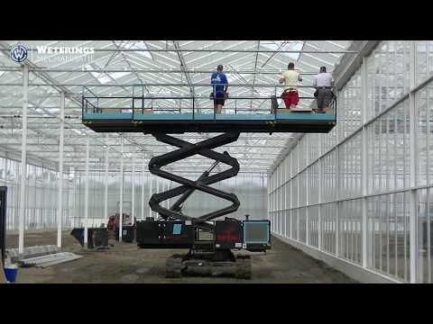 Scherminstallatie in kas installeren met Top Spin 700R Schaarhoogwerker werkplatform op rupsen