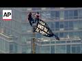 2 People Reach The Top Of The Empire State Building And Hang A Power Of Love Banner
