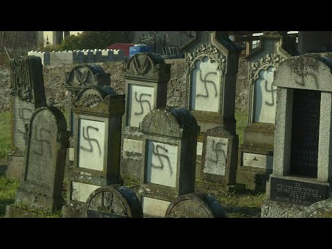 Community leaders visit cemetery where grave stones were defaced with swastikas | AFP