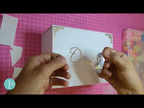 Transferindo adesivo de vinil dourado para caixa em cartonagem