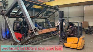 two small forklifts one large load
