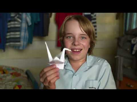 Competition hall still from trailer, crowd watching paper plane flights