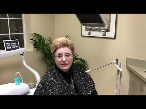Senior woman in black and white leopard print blouse sitting in dental chair