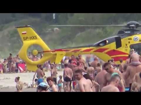 helicopter lands and take off on the beach full of people
