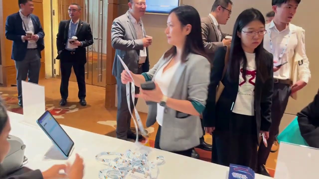 Delegates collecting their badges and lanyards at an event registration desk in Singapore
