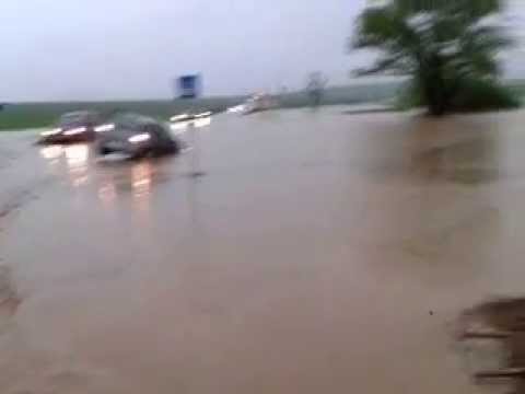 Zaplavená hlavná cesta a havarované auto pri obci Arnutovce