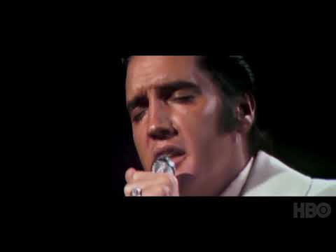 Trailer frame: archival reels and studio tape boxes intercut with Elvis onstage