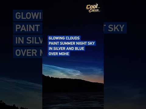 Glowing clouds paint summer night sky in silver and blue over Mohe