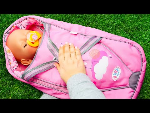 Feeding the baby doll with toy food before going for a walk with a baby bottle.