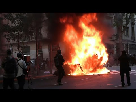 Car burns as clashes erupt between police and protesters at pensioners' march in Argentina | AFP