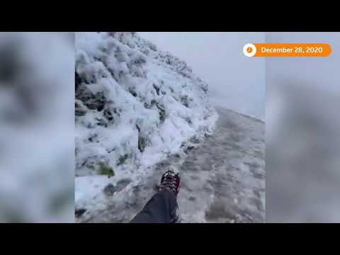 雪橇手在山坡小路上享受雪地環境 (Tobogganist enjoys snowy conditions on hillside path)