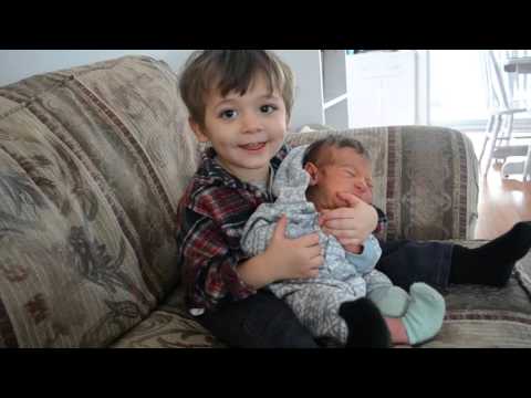 Toddler Holding His Newborn Baby Brother