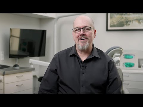 Man in black button down shirt sitting in dental office