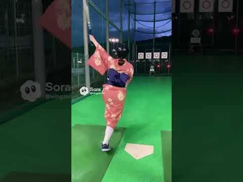 和服姿の若い女性がバッティングセンターで打撃練習。