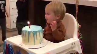Kid grabs lighted birthday candle