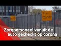 Zorgmedewerkers worden vanuit de auto getest op corona