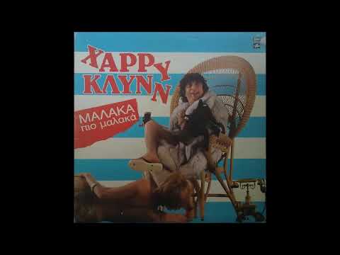 Ο Χάρρυ Κλυνν στο τραγούδι/νούμερο «Μαλακά… πιο μαλακά» (1984). Η σάτιρα λειτουργεί εδώ σε δύο επίπεδα: αφενός το αμφίσημο λογοπαίγνιο της επαναλαμβανόμενης φράσης, που ταλαντεύεται ανάμεσα στην κυριολεξία και στο υπονοούμενο, αφετέρου ο σκόπιμος παρατονισμός, που στρεβλώνει τη φυσική προσωδία της λέξης, οδηγώντας στο κωμικό αποτέλεσμα. Έτσι το φαινομενικά αθώο τραγούδι μετατρέπεται σε καυστικό κοινωνικοπολιτικό σχόλιο, με άμεση αποστροφή στο κοινό.