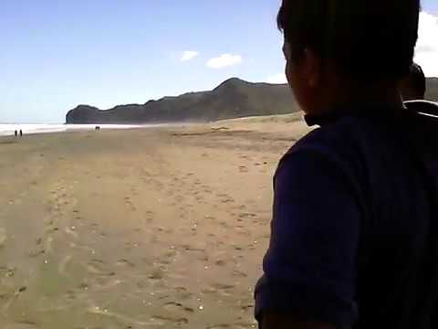Playing with sand at Piha Beach