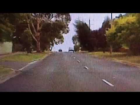 Car drives over round about snd side swiping bike rider.