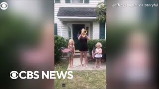 Mom performs "Taps" on trumpet as daughters fly flags for Memorial Day