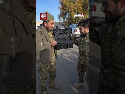 شاهد.. يمني يرتدي بدلة عسكرية يُهدي صديقه السوري مسدسا من نوع 