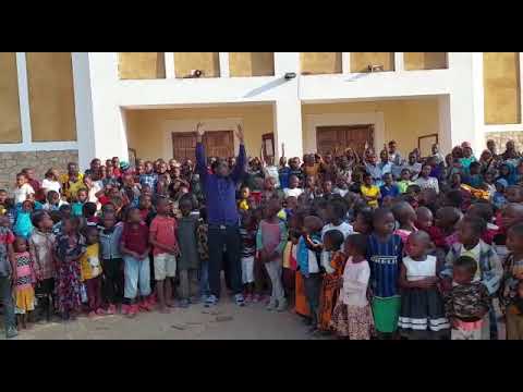 Kinder in Iringa/Tansania singen "Gottes Liebe ist so wunderbar" mit ihrem Priester Moses