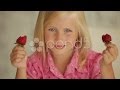 Funny little girl eating strawberries and smiling ...