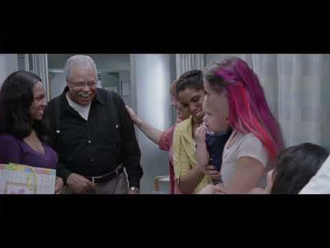 Trailer frame of Apple entering a shelter; score textures underscore vulnerability