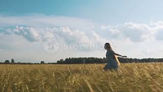Beautiful girl running on sunlit wheat field  Slow motion 120 fps  Sun lens flare  Freedom concept