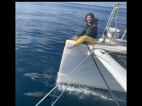 Valkyrie Sailing Charters Sailing from Montauk Point to Florida in the Atlantic Ocean. Nicole sitting at bow watching the dolphins play.