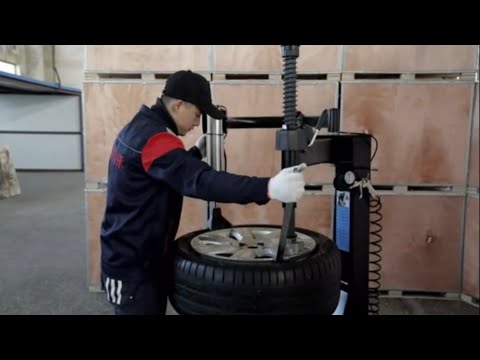 Using a tire machine assist arm