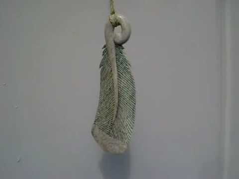 Whale bone Huia feather pendant blowing in the wind
