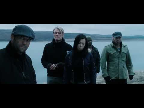 Frame from The Expendables 2 Official Trailer showing the ensemble cast and explosive action tone