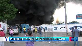 Bomberos trabajan para sofocar el incendio en el almacén de Plaza Lama de la autopista Duarte