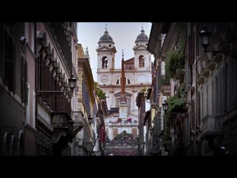 Upward slow motion tilt from street to Via Dei Condotti