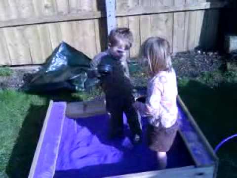 milly an chris in the garden playing in the sand